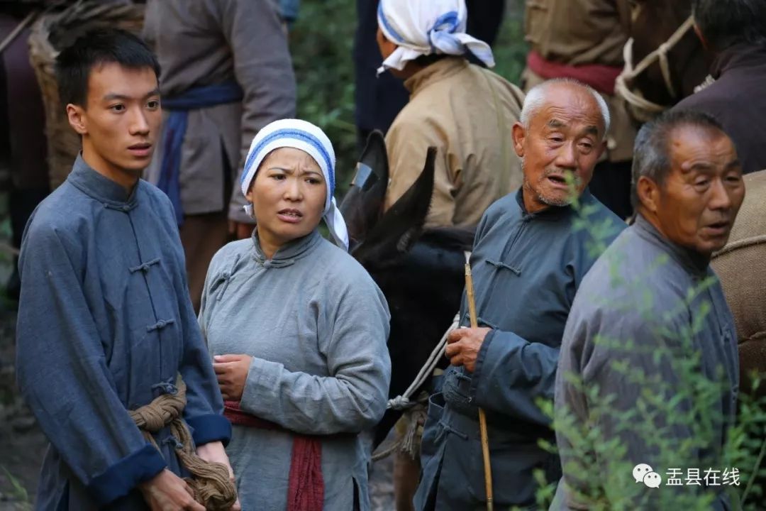 在电影导演的现场指挥下,乡亲们3人一组,赶着小毛驴,通过羊肠小道