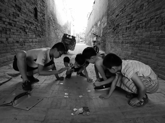 在平遥城内转悠的时候,遇到一些小孩正在玩"拍卡片"游戏,这个场景让