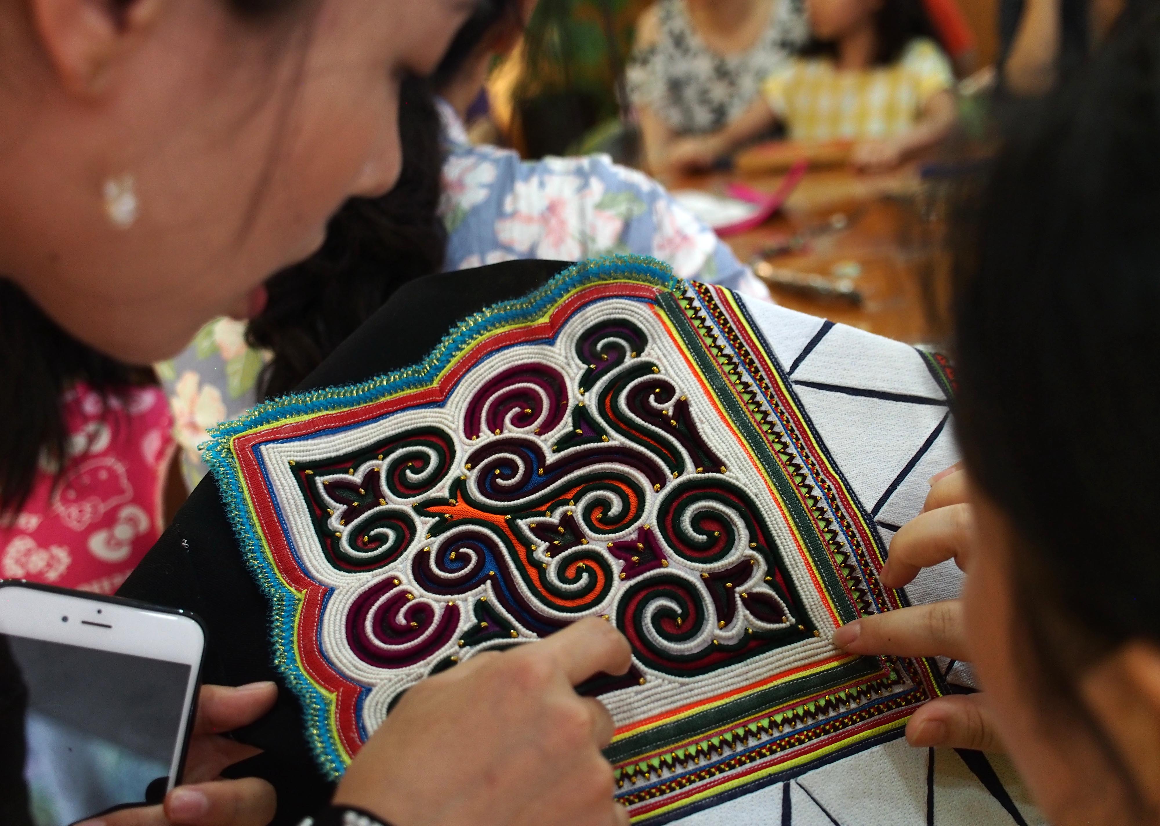 4日都市里的彝绣传习课8月4日,彝绣体验班的学员在研究彝绣的基本针法