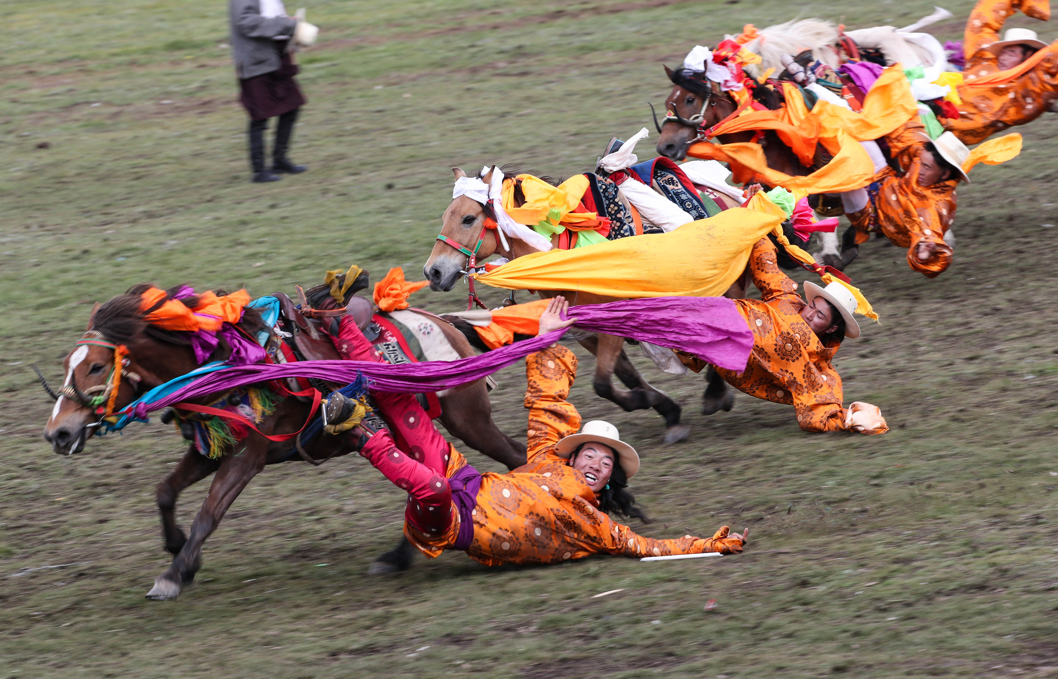 当日,四川省理塘县八一赛马节开幕,近千名牧民展示拾哈达,马上射箭