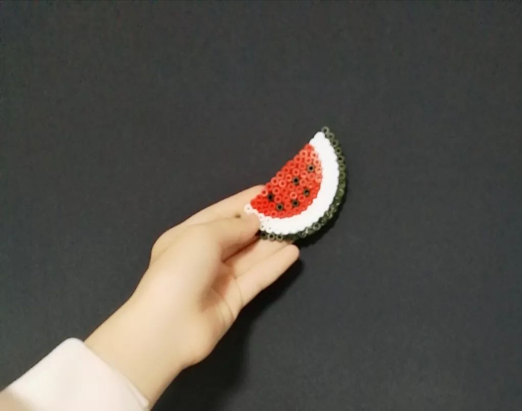 除了剪纸,还有拼豆豆,老师会发给我们一桶五彩缤纷的小"豆豆"和一块