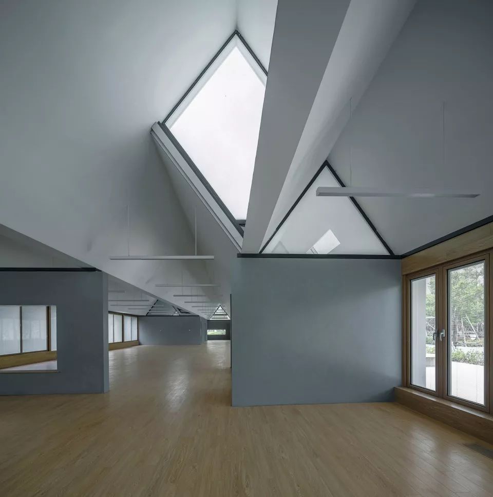 片墙,这样可以在坡屋顶和混凝土墙之间形成大小不一的三角形高侧窗,为