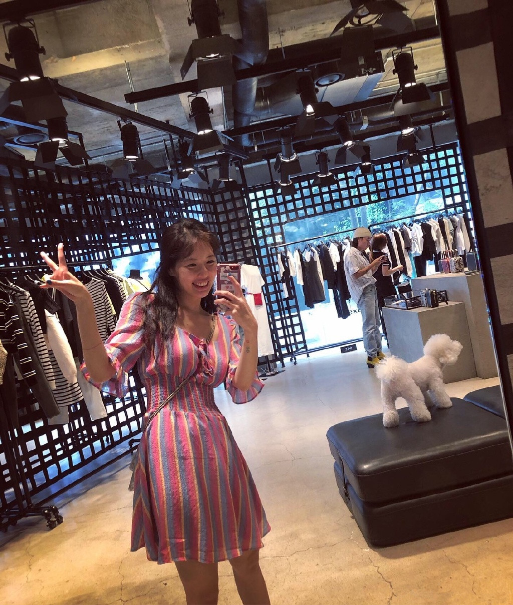 一组素颜自拍照,照片中的泫雅穿着粉色条纹连衣裙带着狗狗在逛服装店