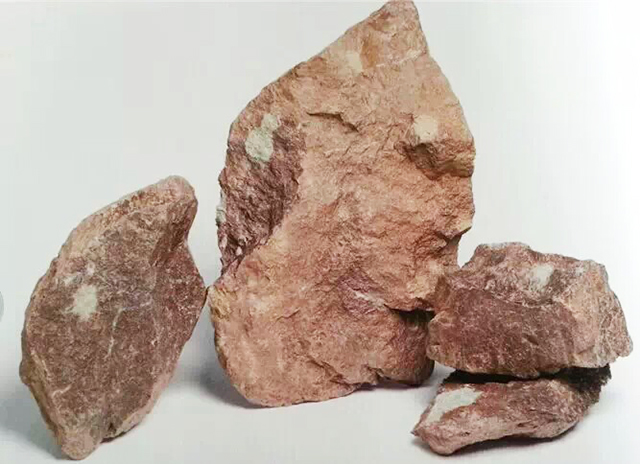 矿料外观呈紫褐致密块状,比较坚硬,含有一定量的白色云母碎片,矿料上