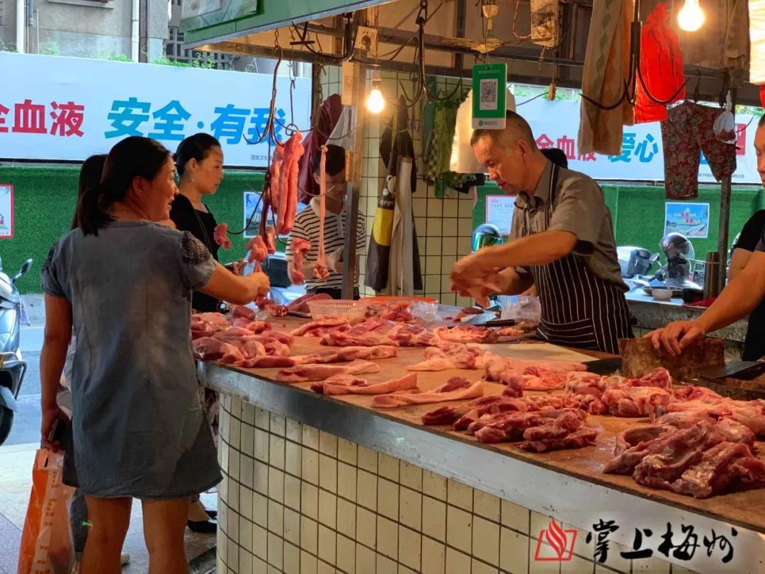图为市民在梅城某菜市场猪肉摊档选购猪肉(张怡 摄)昨日,记者走访了