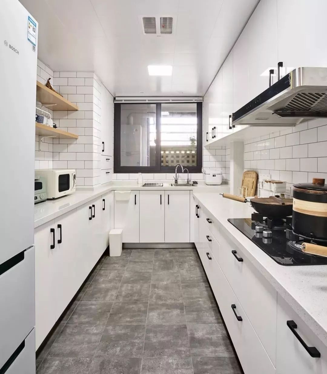 u型厨房,水泥色地砖搭配工字铺白色墙砖,柜体同样采用白色基调