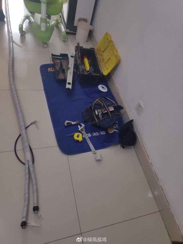 在将专业空调安装工具摆放开来之前,师傅在用户家的地面上铺上一块