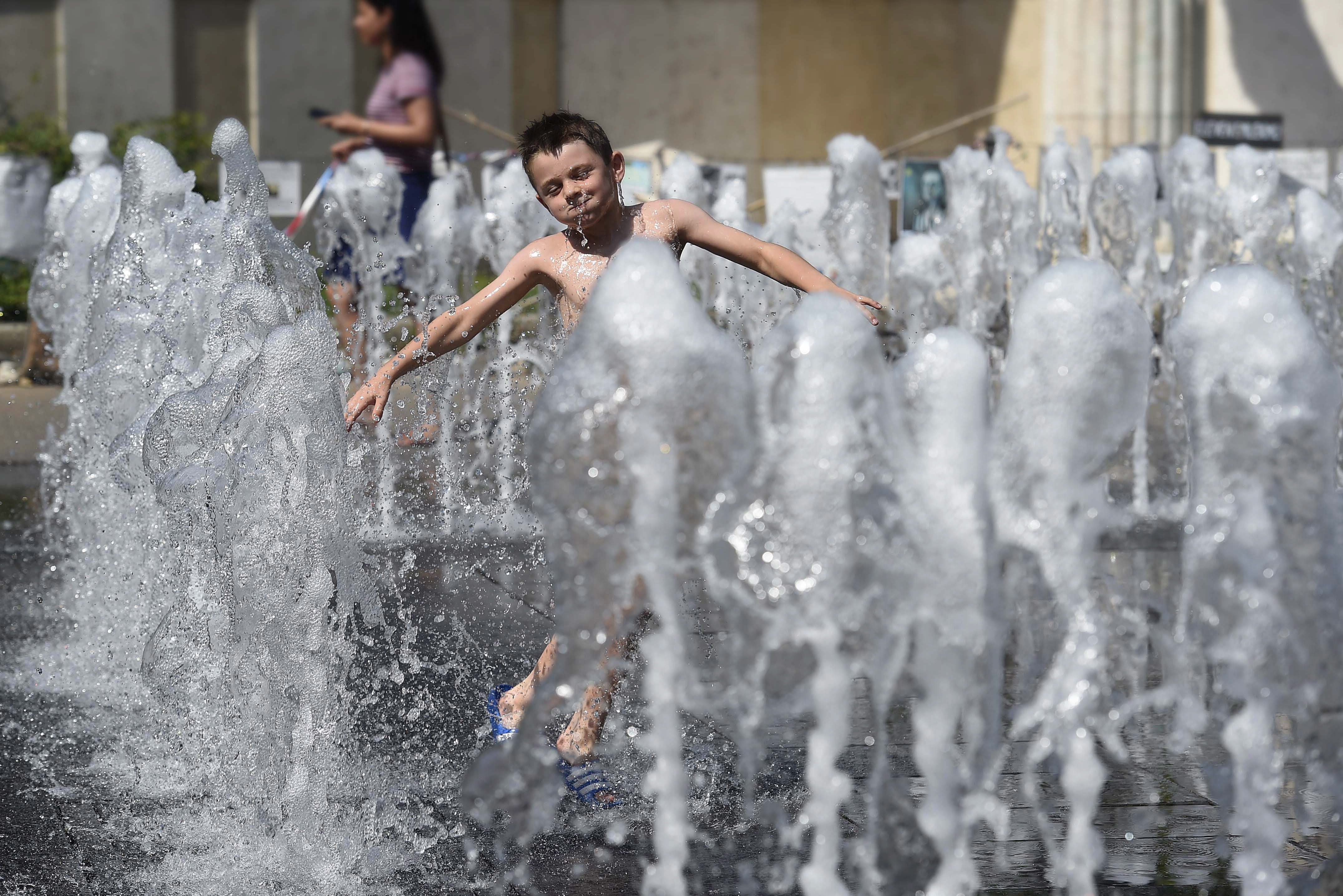 8月12日,在匈牙利布达佩斯,一名小男孩在喷泉处戏水