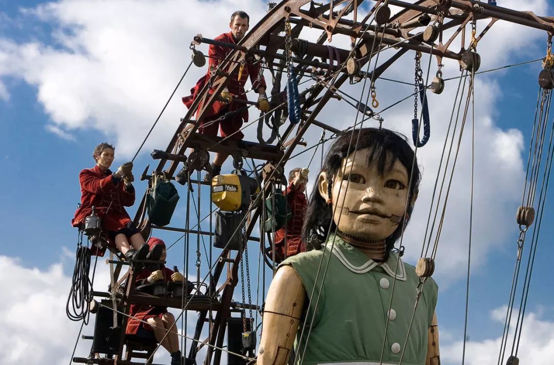 剧团成员正在操控一只巨型木偶从水中浮出的潜水员木偶在市中心巡游的