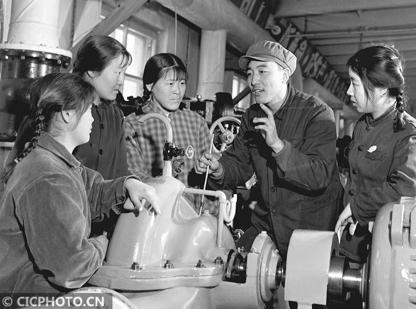 工人技术员和工人一起检修钻机↑儿童在缝补厂的阿姨带领下,自己
