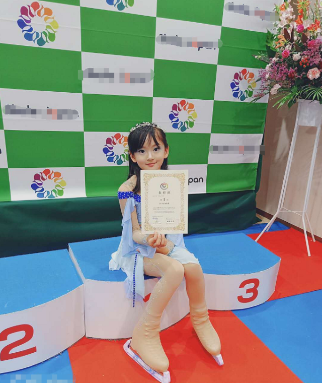 莫芷嫣站在领奖台上,莫少聪站在前面,父女两人对着镜头露出微笑