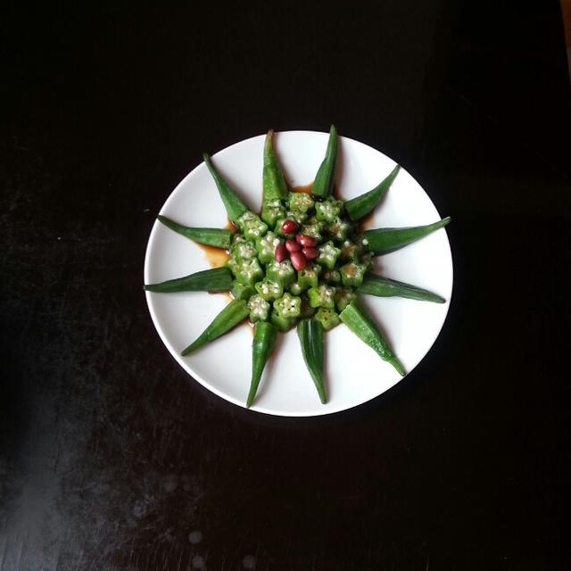 放开水锅中淖水一分钟,捞出放入冰水中降温秋葵切去蒂,切小块摆盘,浇