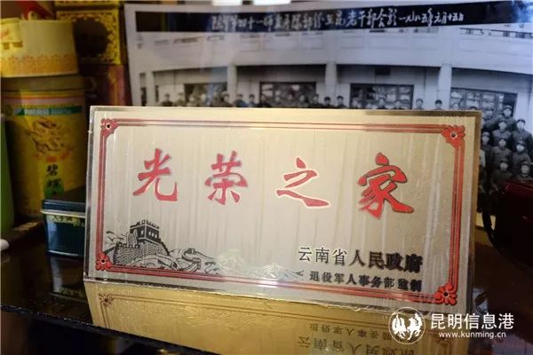 遗像下面放着还没有揭去保护膜的"光荣之家"光荣牌