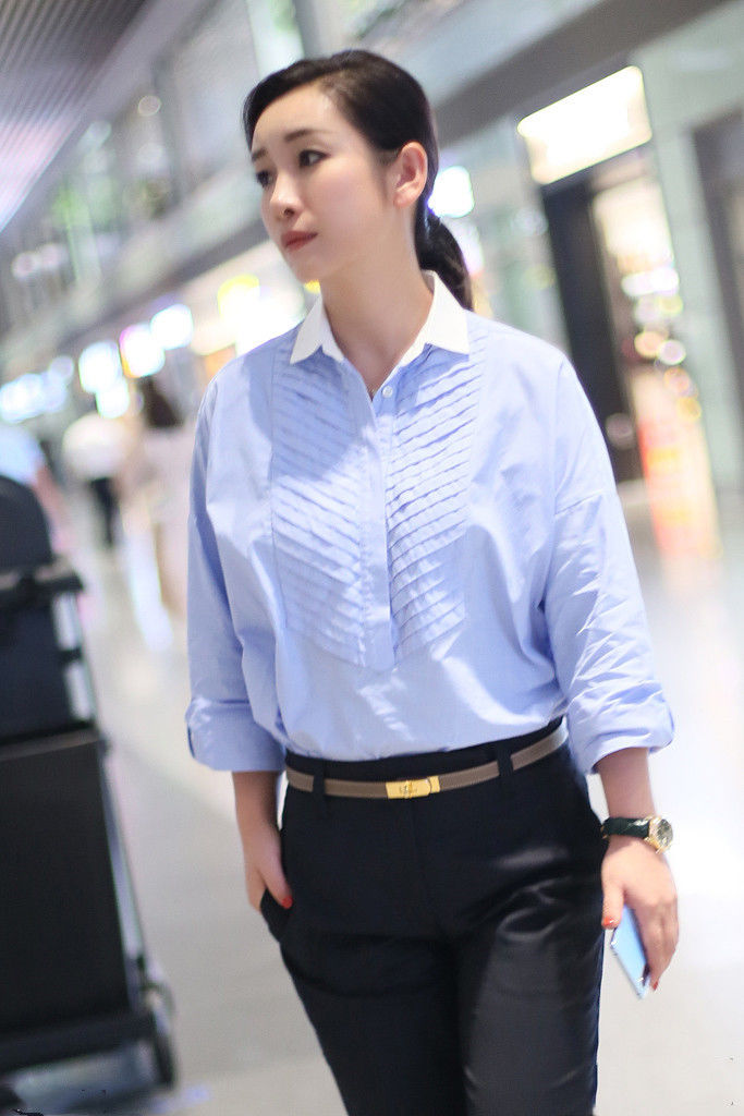 41岁秦海璐走机场衬衫搭配九分裤洒脱干练低绑马尾更显好气质