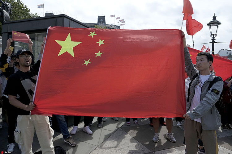 美国纽约唐人街孔子大厦前,留学生和华人华侨高举国旗,声援香港警察