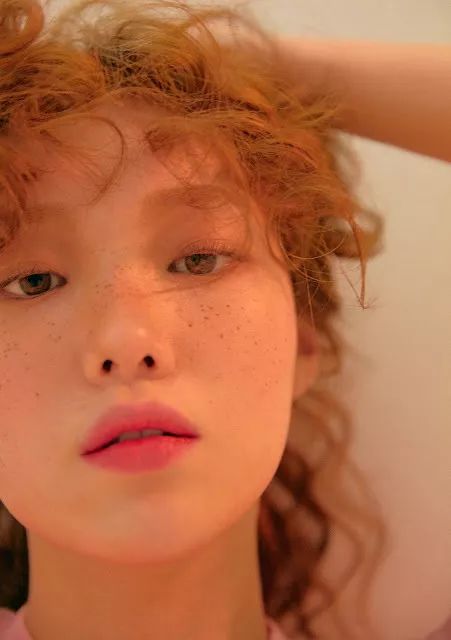 李圣经的小雀斑妆容搭配一头浪漫的卷发和粉色的口红,慵懒中又带有一