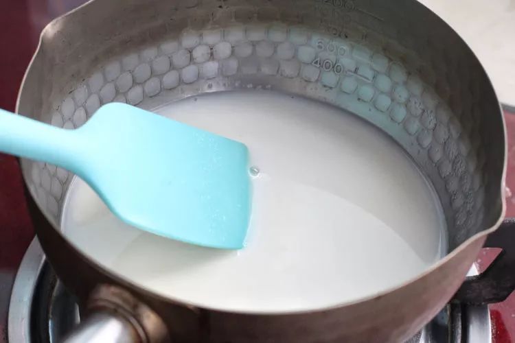 将牛奶,60克细砂糖和盐一同倒入小锅中,小火加热搅拌至糖完全融化,煮