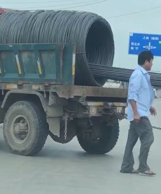 在宾阳新宾南桥头马路上发生了一起交通事故,一辆拉运钢筋的拖拉机在