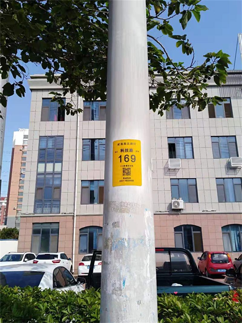 市政局的路灯工作人员正忙着给辖区内的路灯杆上粘贴一块黄色的小标牌