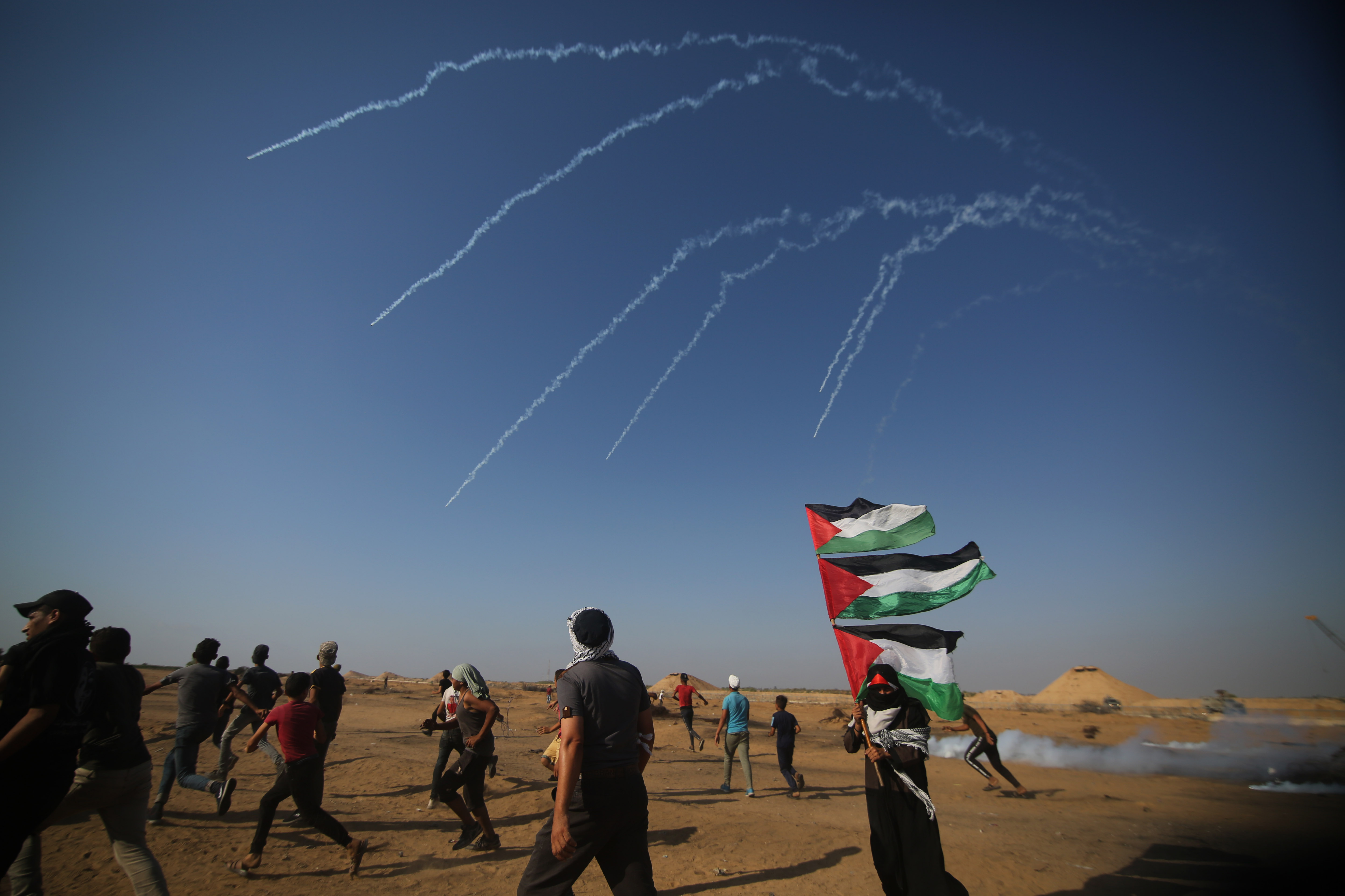 地带与以色列交界地区,巴勒斯坦示威者躲避以色列士兵发射的催泪弹