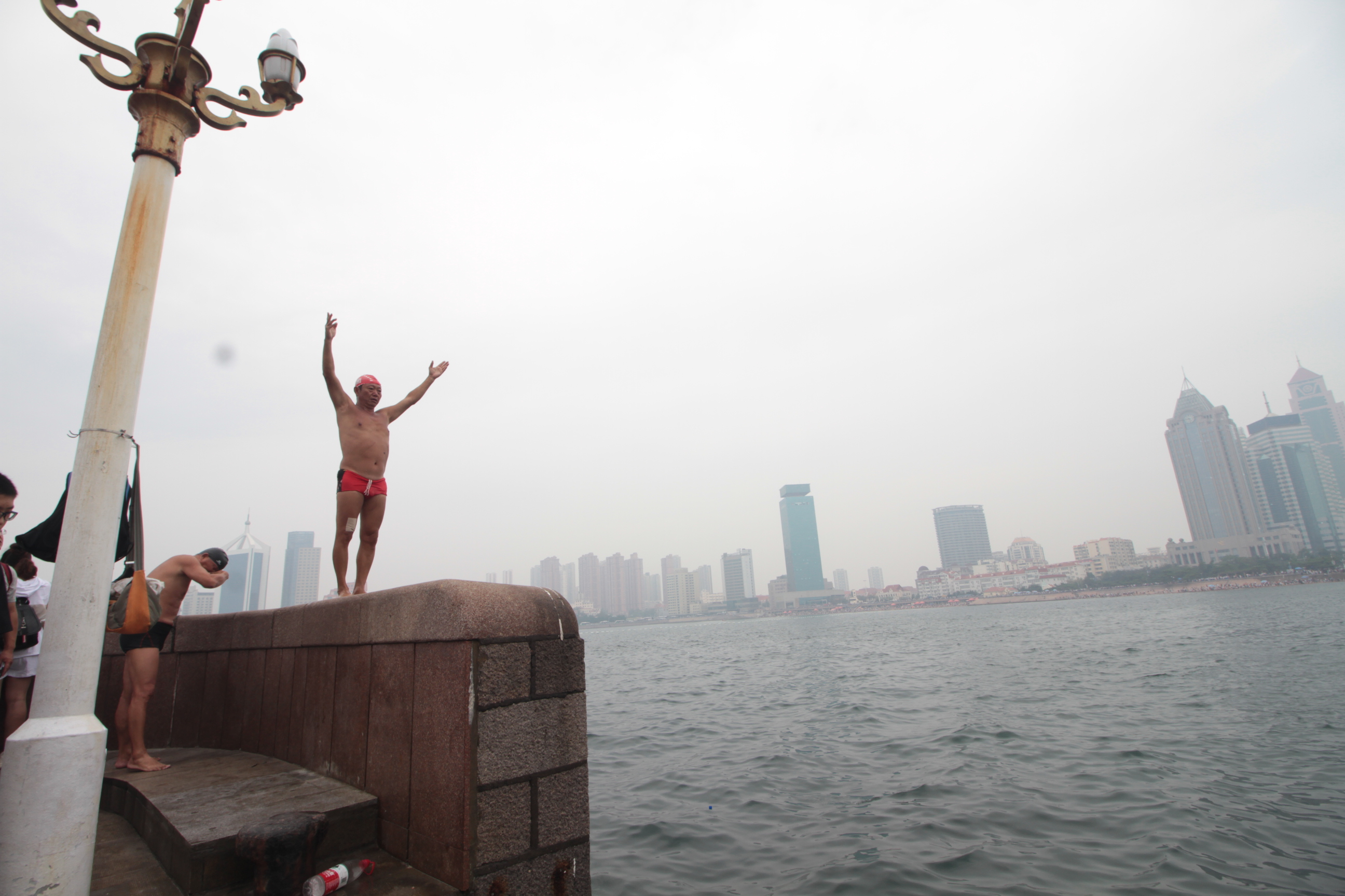 原创青岛大爷花样跳海成栈桥一景游客争相拍照留念