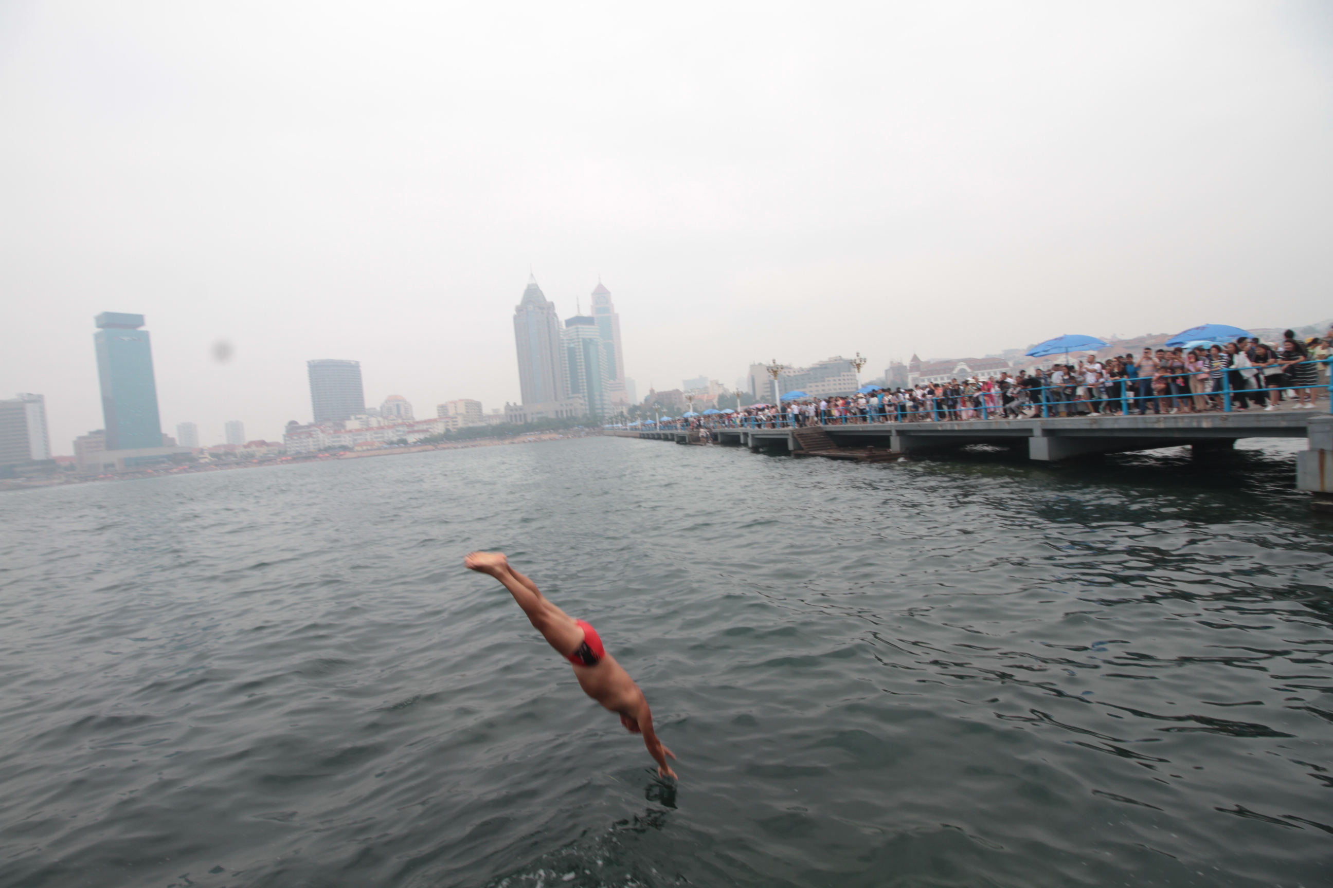 原创青岛大爷花样跳海成栈桥一景游客争相拍照留念