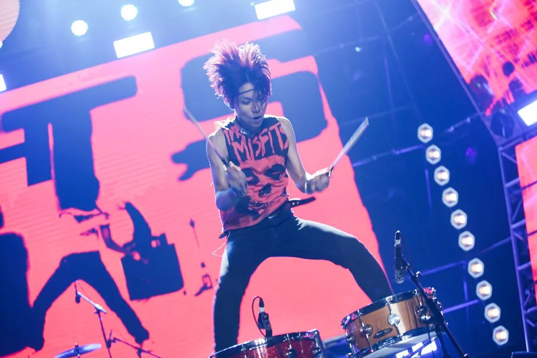 新裤子乐队成员在台上激情开唱,跳跃,扭动身体乐迷们在台下疯狂尖叫