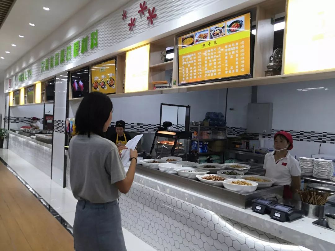 同学们正在与餐口商讨价格正在与食堂职工交谈并进行质检的同学们本次