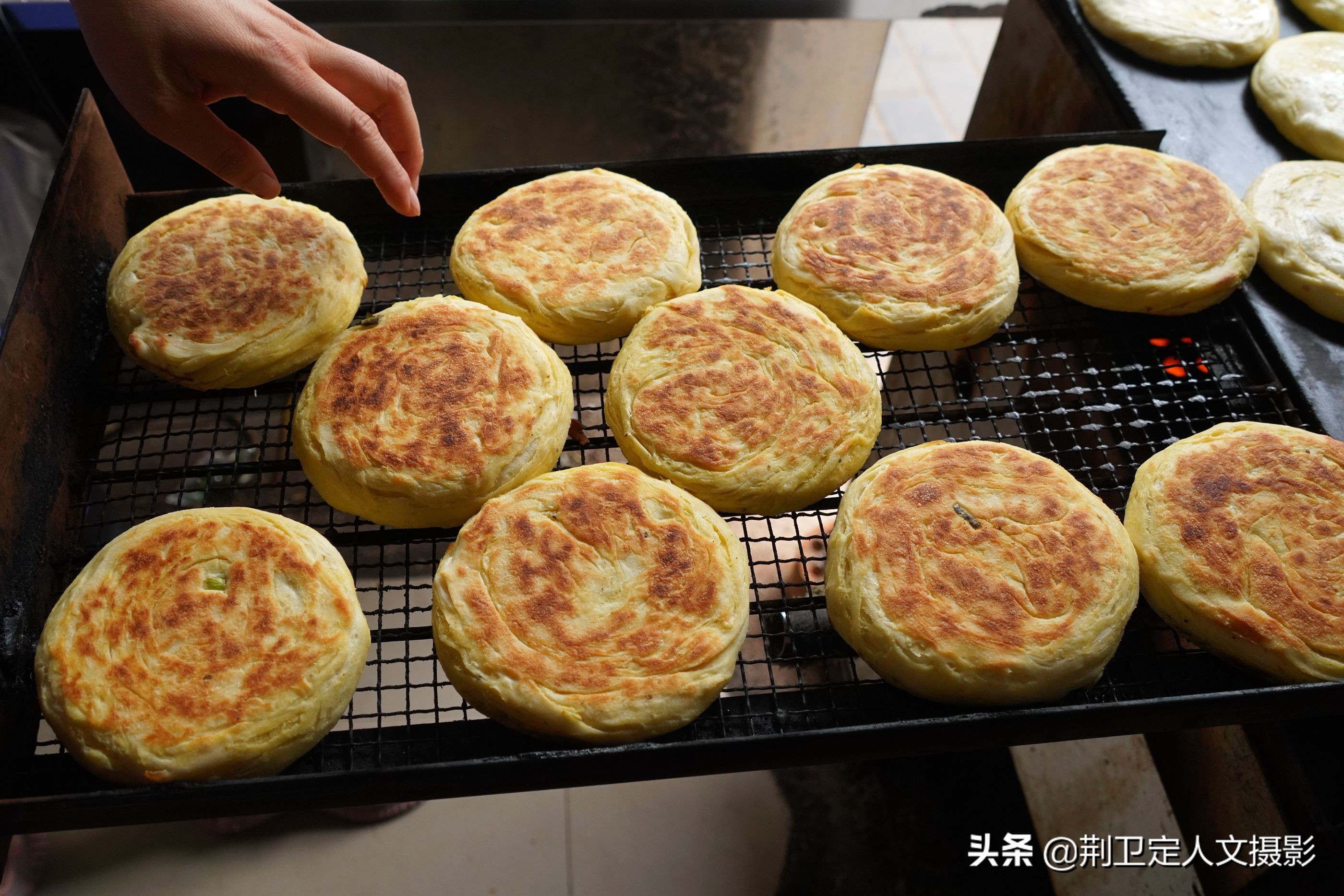 1 12 陕西省洛南县城的一个街头小饼子店前,每天买小饼子的食客总是