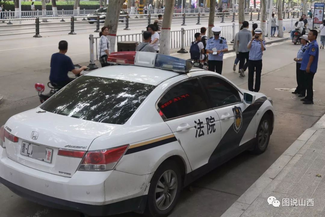 有一辆法院的警车长时间违法停放在非机动车道上,被联合执法交警贴了