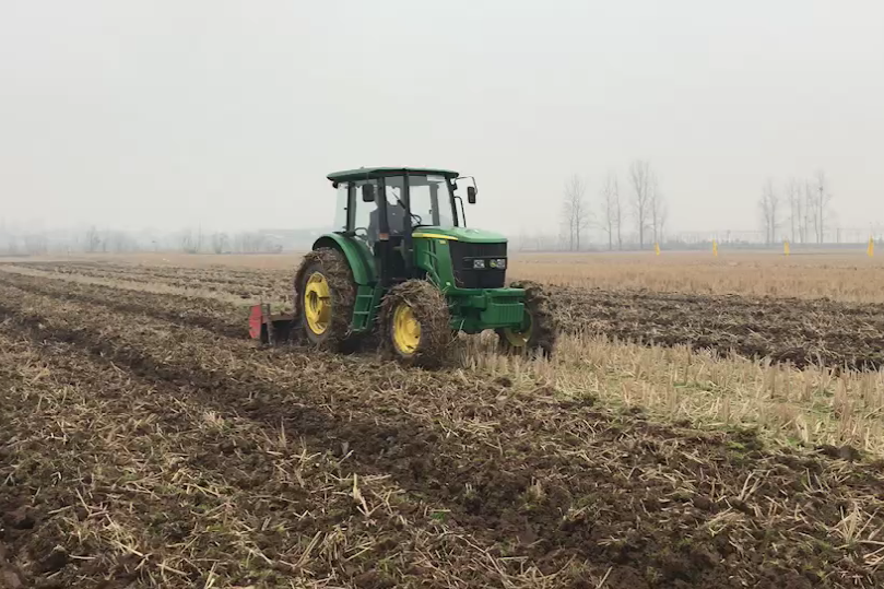 约翰迪尔6b1204拖拉机正在进行农田旋耕作业