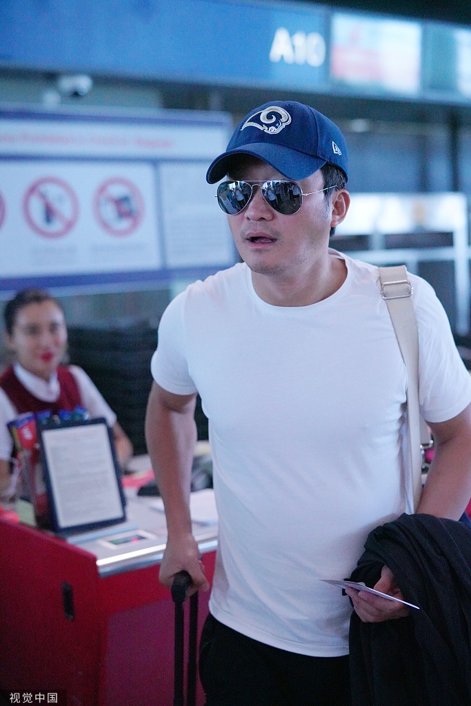 吴京穿休闲白t现身机场 安检口霸气指导狗仔正能量