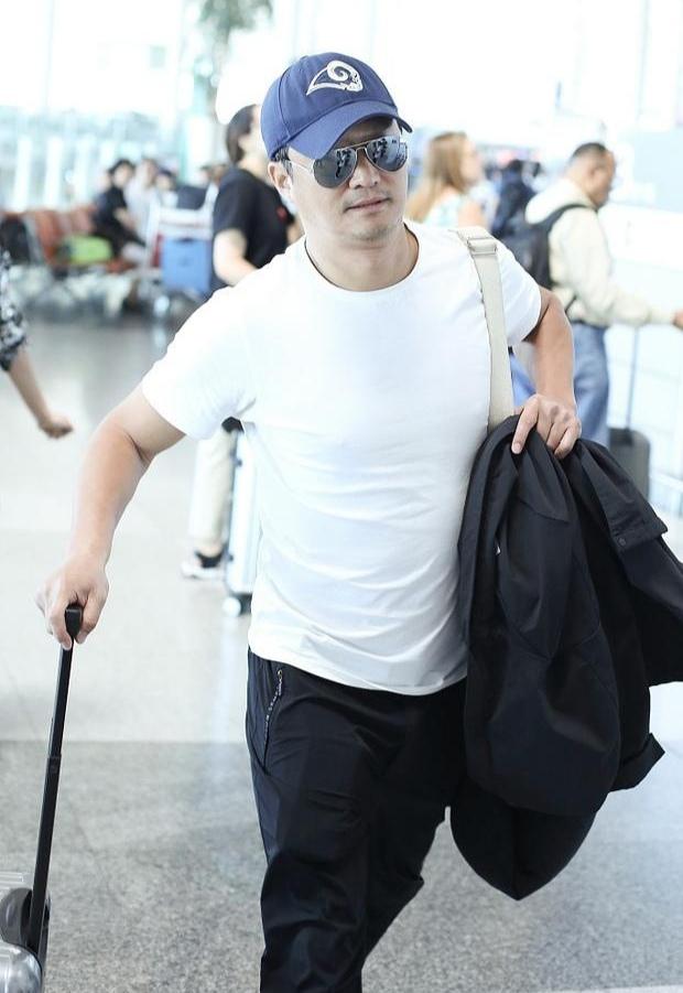 吴京一身白衣黑裤潇洒走机场,走路有范儿引路人围观_身材