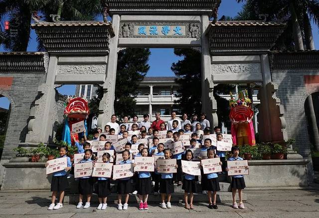 "文学流风"牌坊合照沙湾镇京兆小学麦志亮校长为一年级新生颁发证书