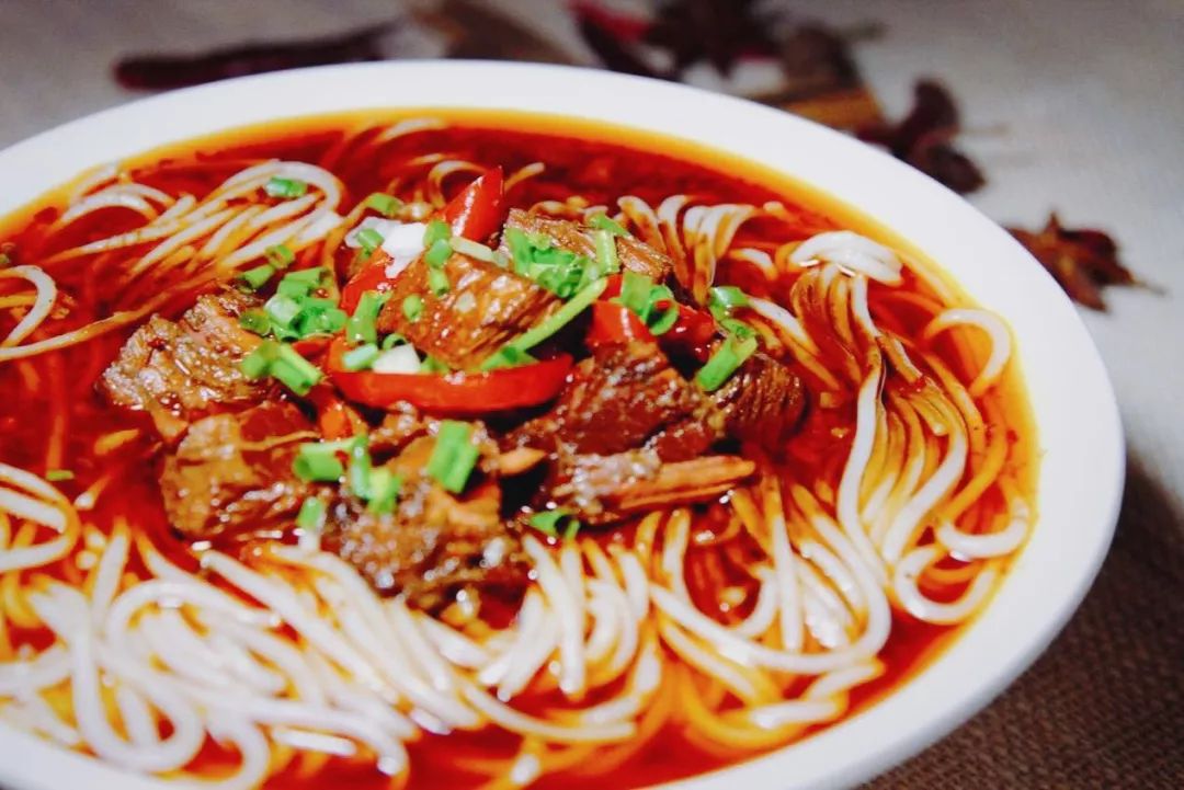 将煮好的米粉放在碗中,酥软的牛肉连汤带肉趁热浇上一大勺,再抓一把