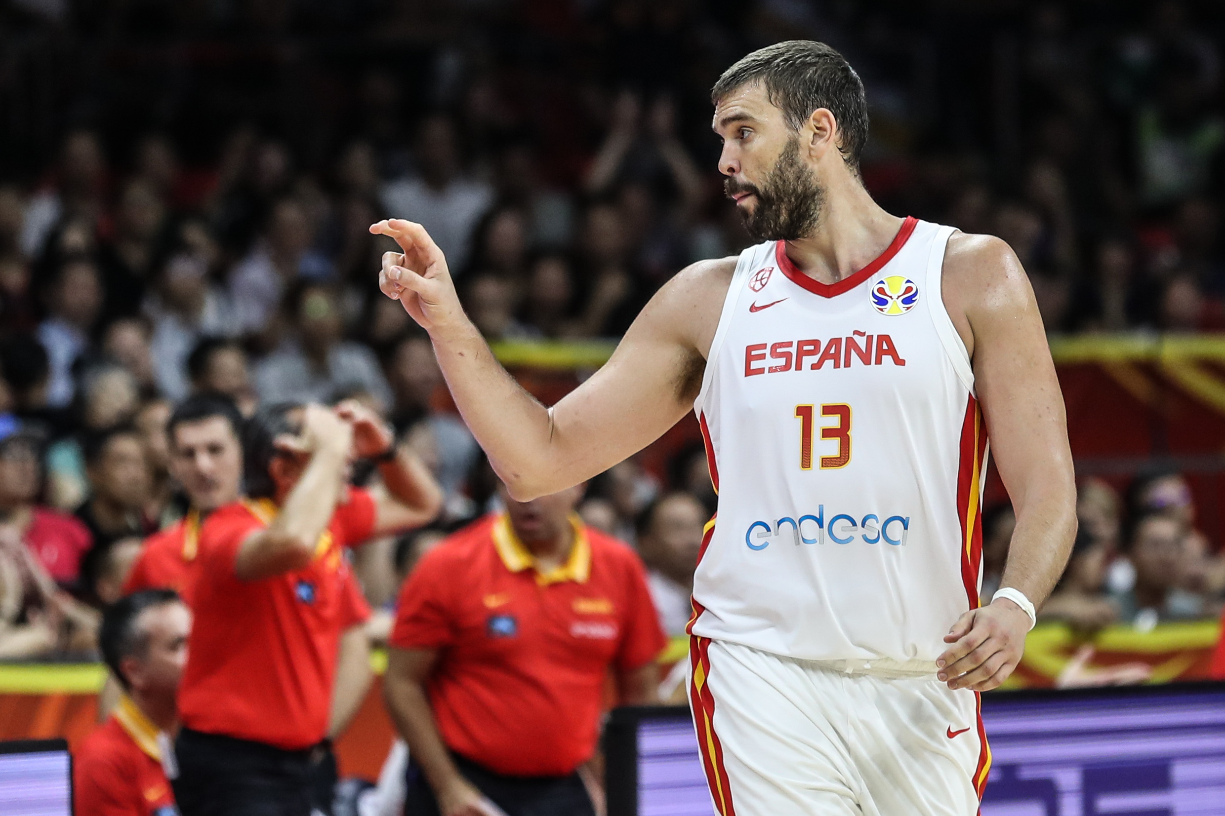 西班牙队球员加索尔(右)与伊朗队球员哈达迪在比赛中交流