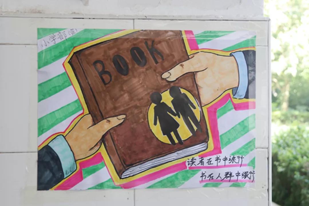 学生一同粘贴图书漂流活动海报同学们观看图书漂流活动海报高中部图书
