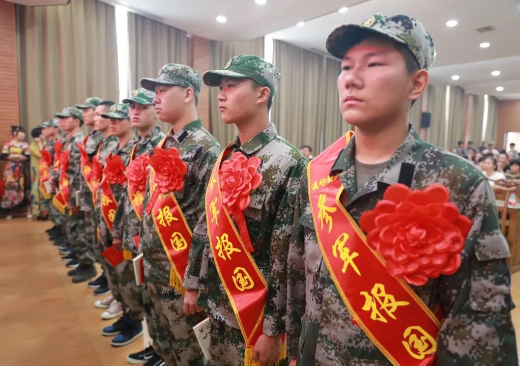 激昂的点名仪式过后,父母们分别上台,亲手为新兵们佩戴大红花和绶带