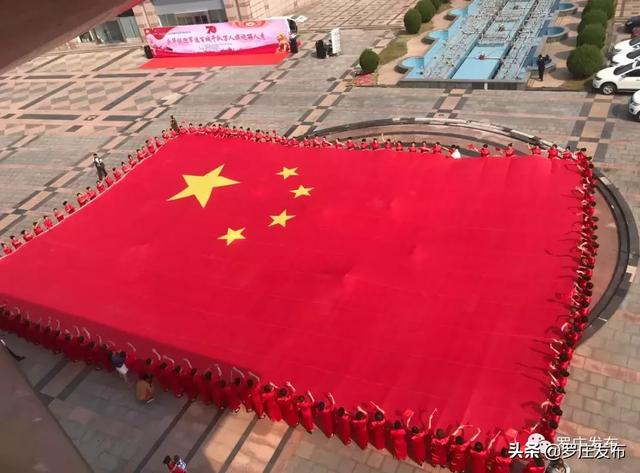 中华人民共和国成立70周年献礼向高唱爱国歌曲手持400平米国旗"中国红