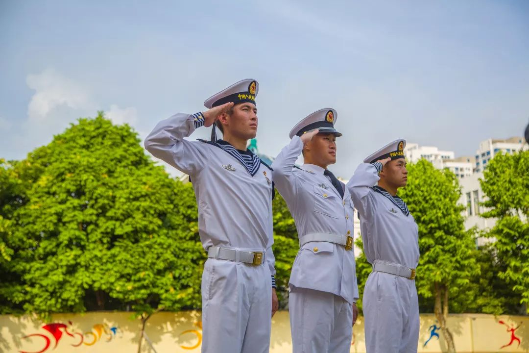 出旗曲奏响,特邀来校的海军国旗护卫队的三名战士捧着鲜红的五星红旗