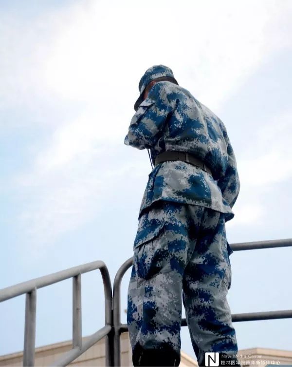 从蔚蓝高空的视角下看到教官酷酷的背影站在哨台上浑身充满力量像是向
