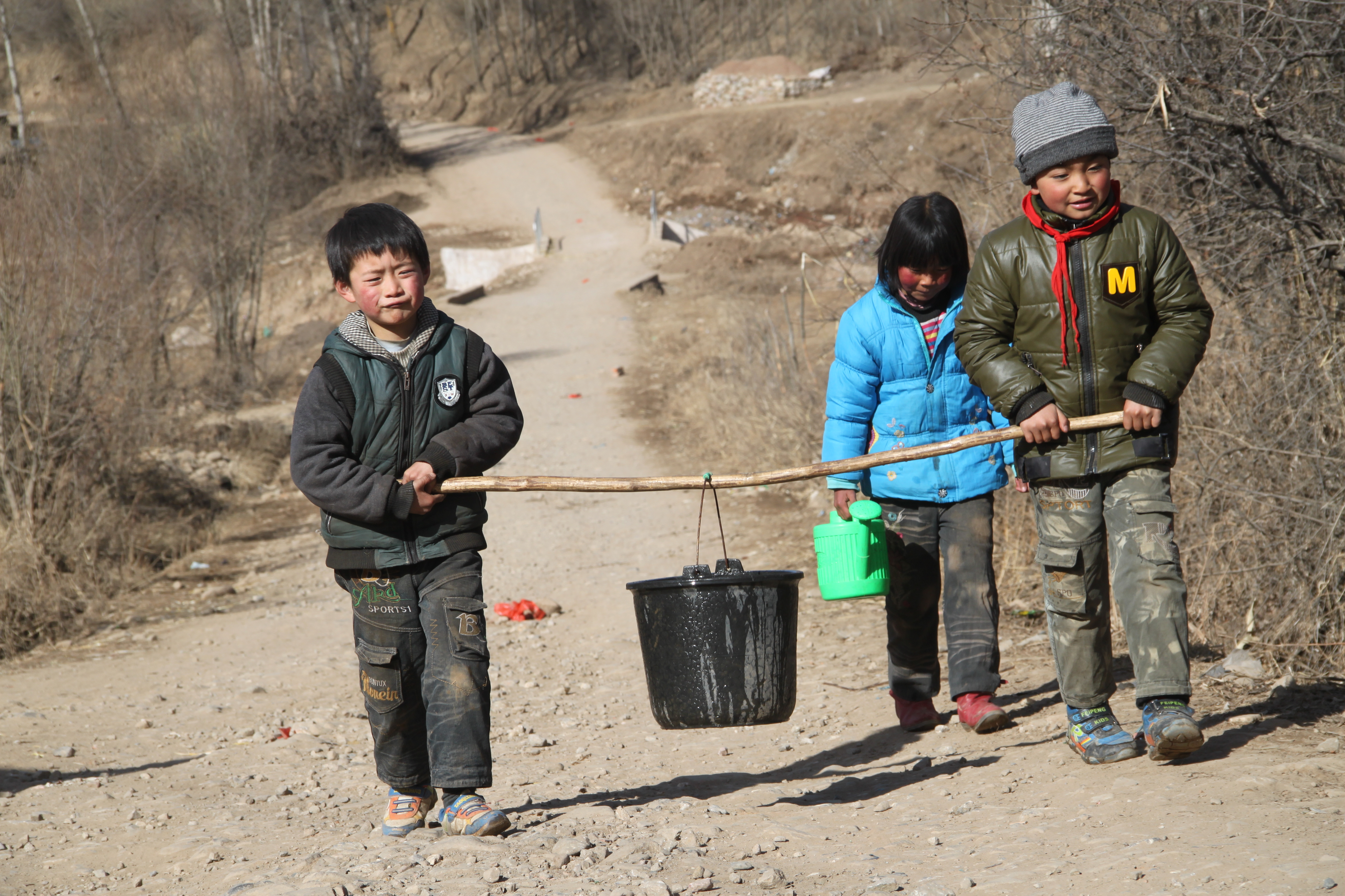 脱贫前,渭源县元古堆村的孩子们从取水点抬水.摄于2013年3月.