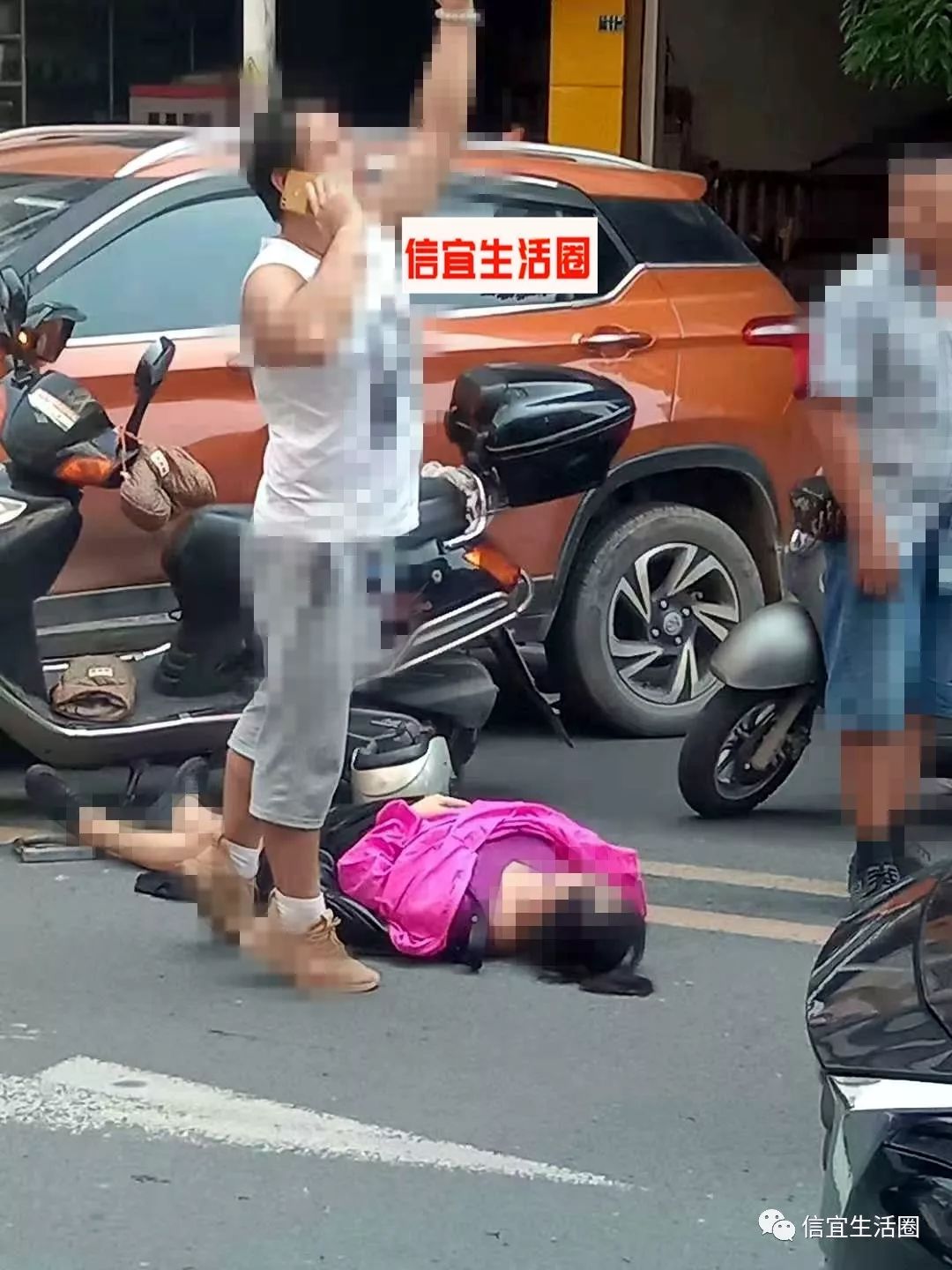 信宜城北一小对出路段摩托车小车相碰一女子倒地不起