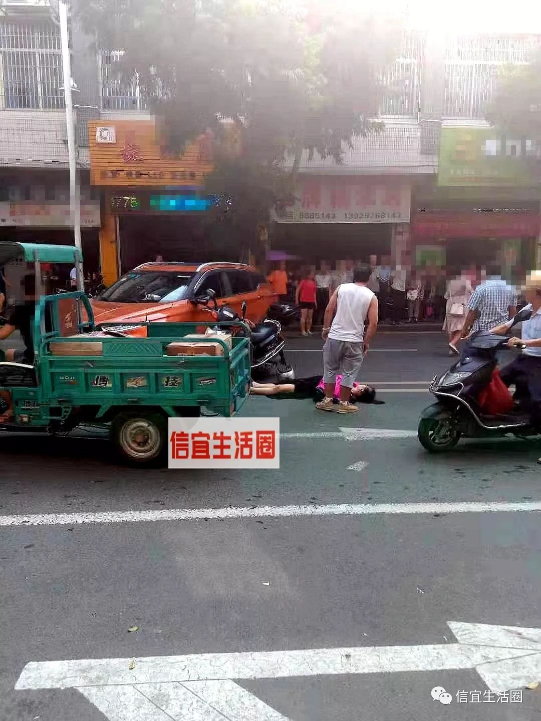 信宜城北一小对出路段摩托车小车相碰一女子倒地不起