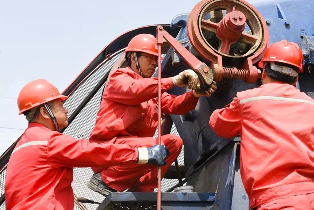 员工们在抽油机游梁上更换尾轴黄油,做好设备换季保养工作.