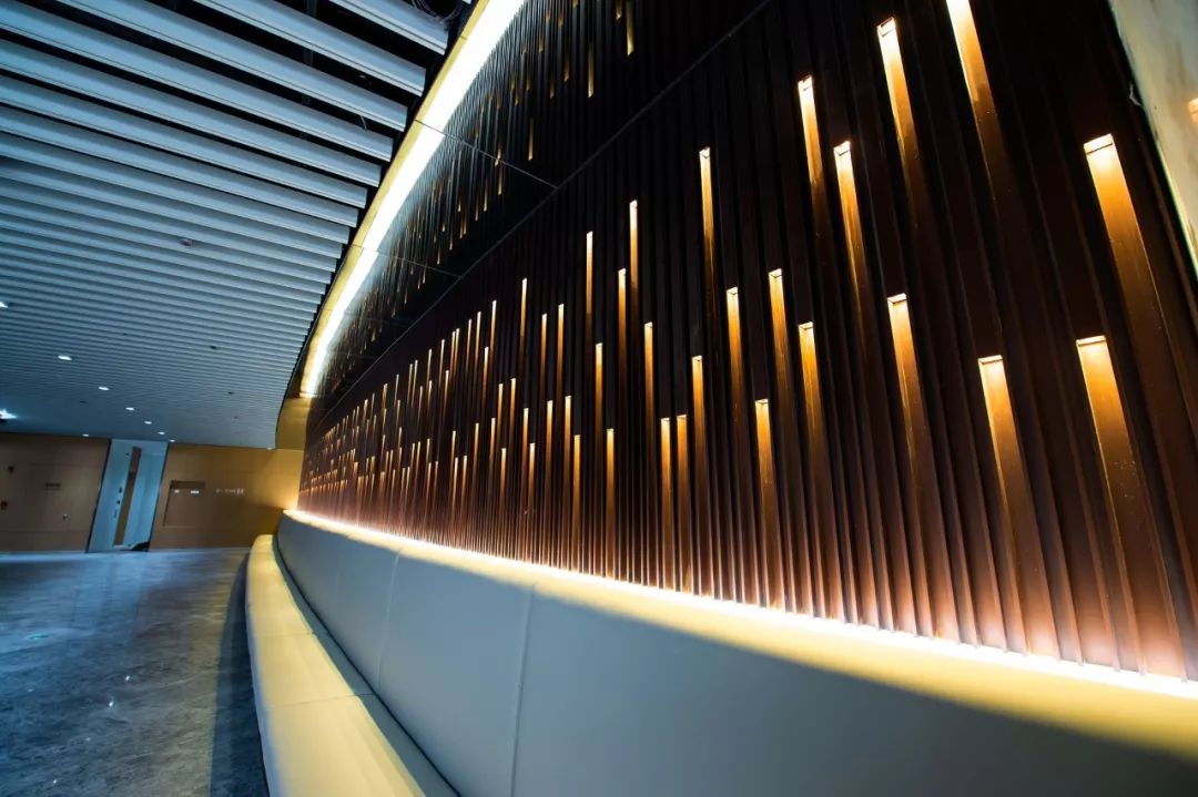 s1国际贵宾室通道背景墙使用了金属格栅配上"繁星"点缀的灯光效果,尽