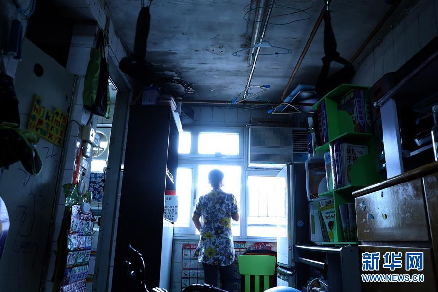 家住香港彩虹邨公屋的王女士站在狭小的房间内(9月17日摄)