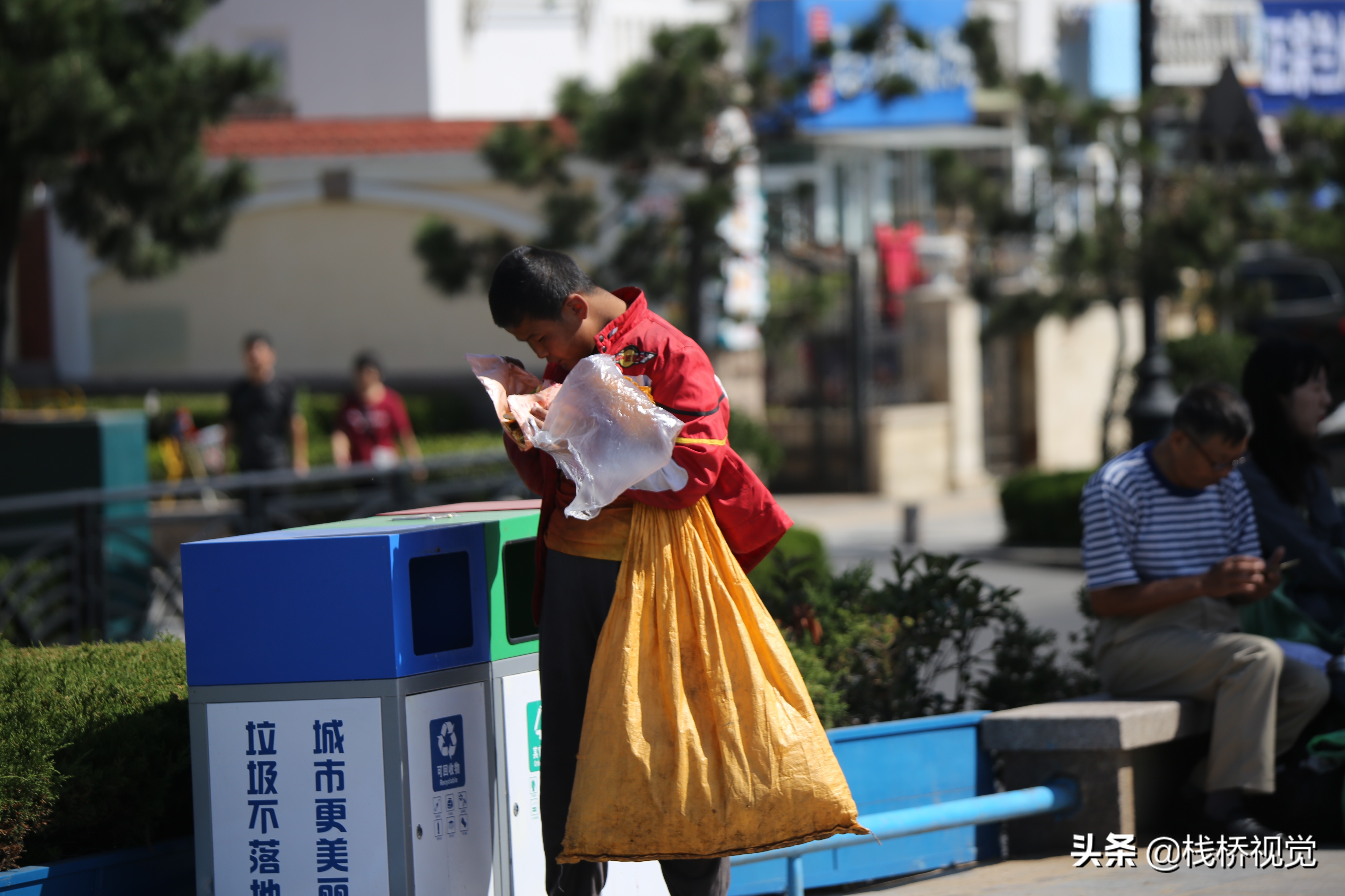 青岛栈桥景区捡垃圾的孩子翻垃圾桶喝别人剩饮料吃扔掉的食物