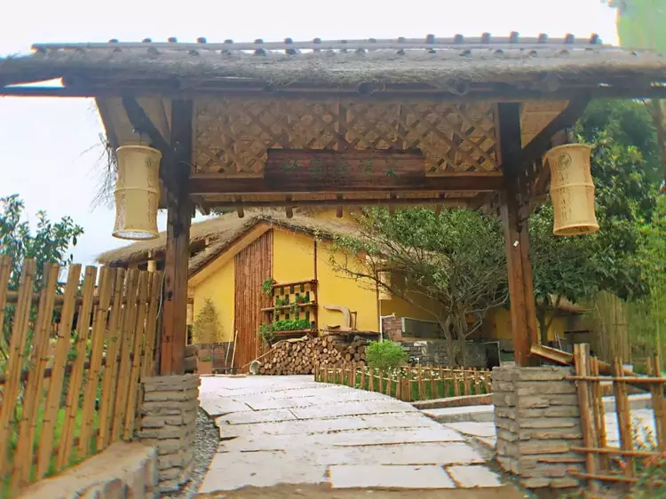 一座古色古香的农家小院坐落在竹林之中,栅栏,木柴,茅草屋顶……看着