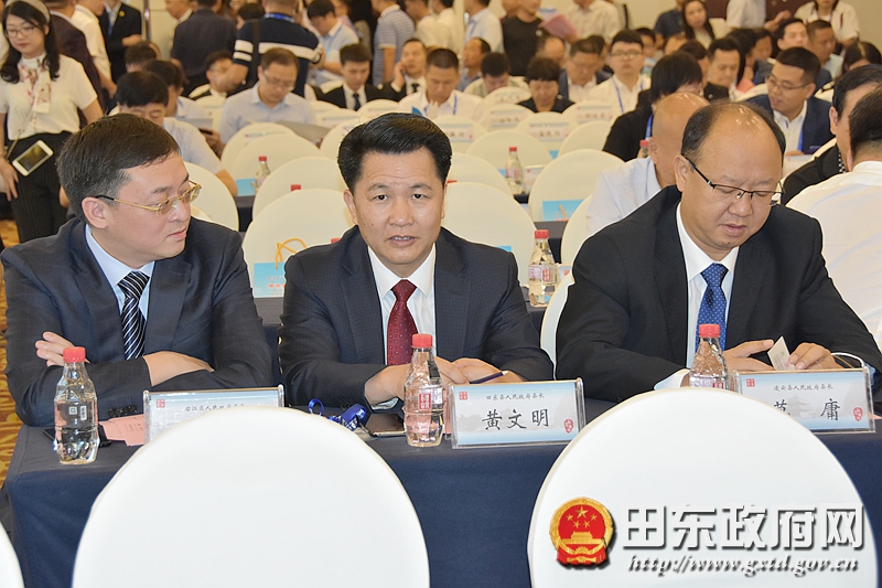 图为黄文明(中)参加项目签约仪式图为谢晓岗(左)